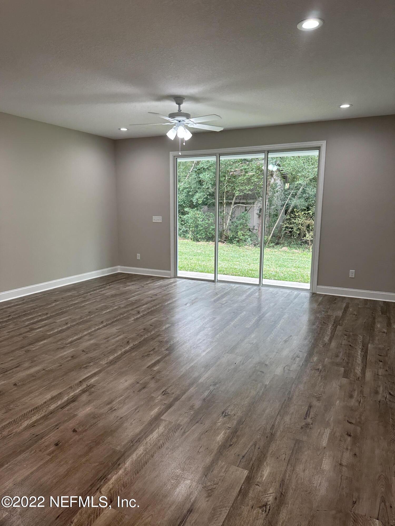 6458 Heidi Road Jacksonville, FL 32277 - Photo 12 of 26 en view of an empty room with wooden floor and a large window