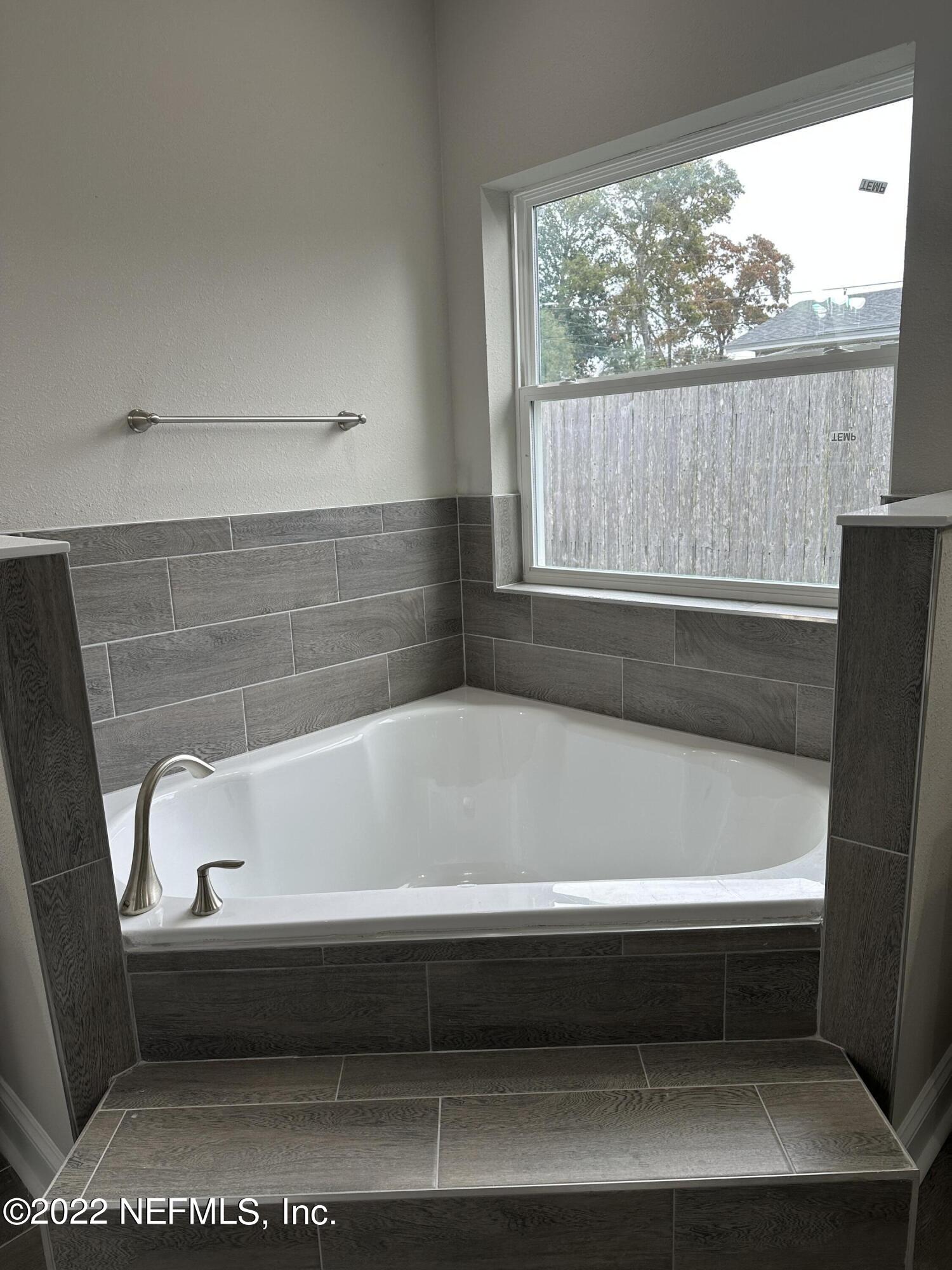 6458 Heidi Road Jacksonville, FL 32277 - Photo 15 of 26 a bathroom with a bathtub and window