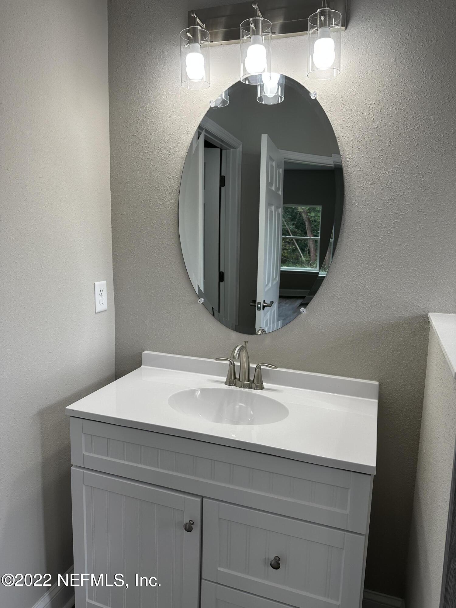 6458 Heidi Road Jacksonville, FL 32277 - Photo 18 of 26 a bathroom with a sink and a mirror