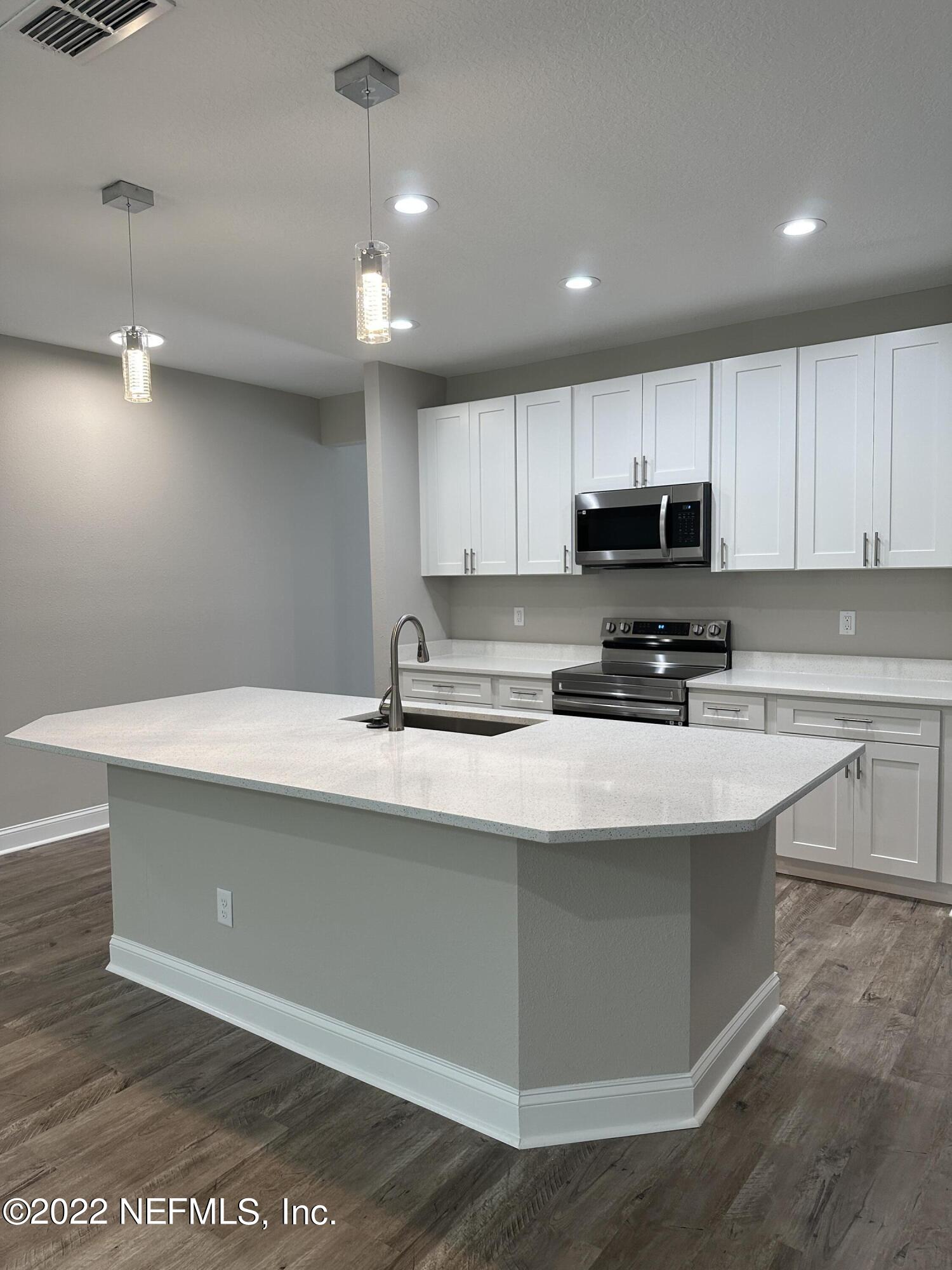 6458 Heidi Road Jacksonville, FL 32277 - Photo 6 of 26 a kitchen with kitchen island a sink stainless steel appliances and cabinets