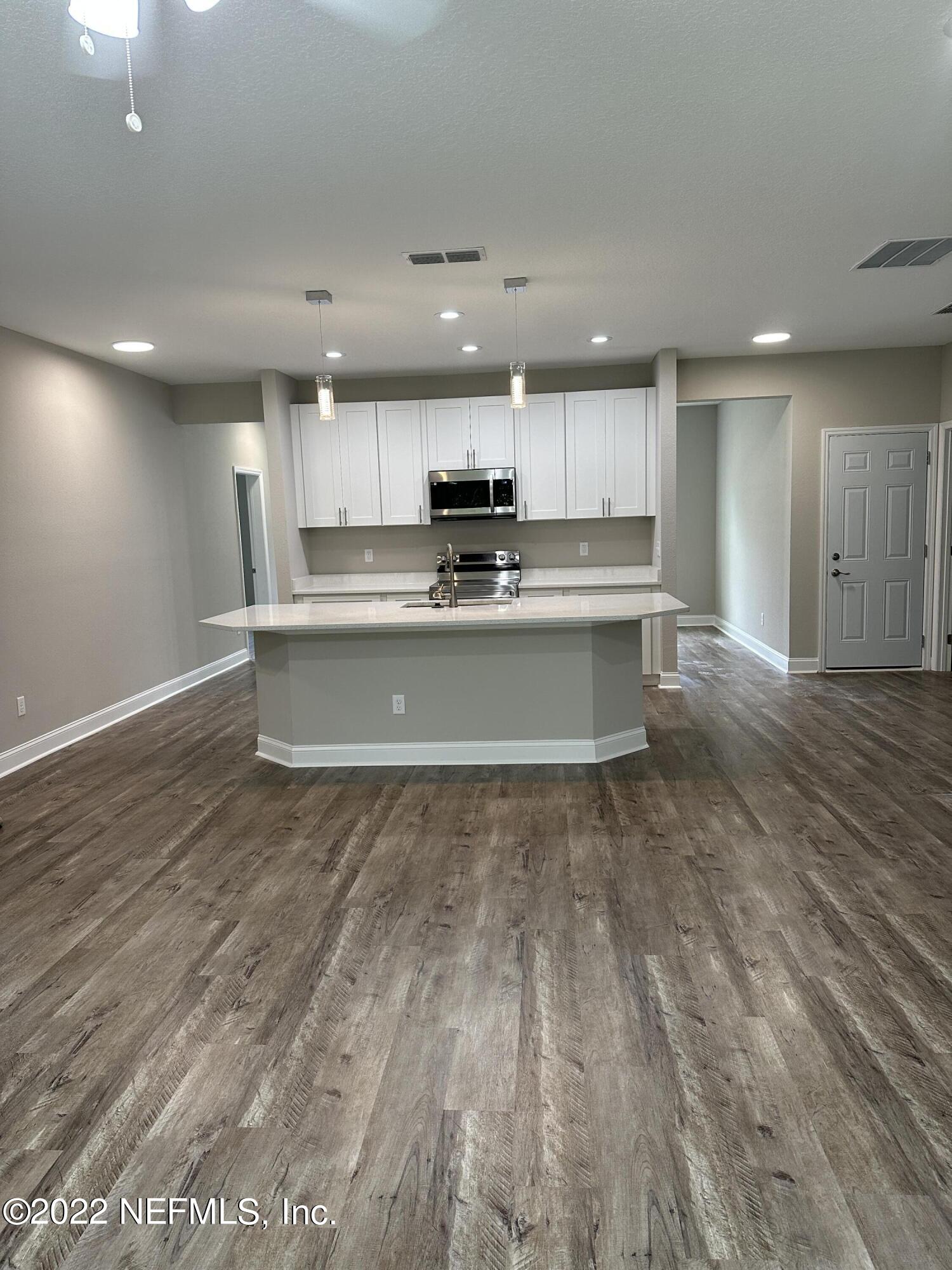 6458 Heidi Road Jacksonville, FL 32277 - Photo 8 of 26 a view of kitchen with kitchen island wooden floor center island and stainless steel appliances