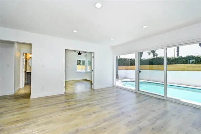 an empty room with floor to ceiling window and an outdoor view