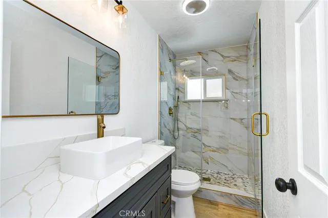 a bathroom with a sink toilet a mirror and shower