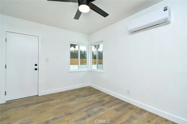 an empty room with a window and ceiling fan