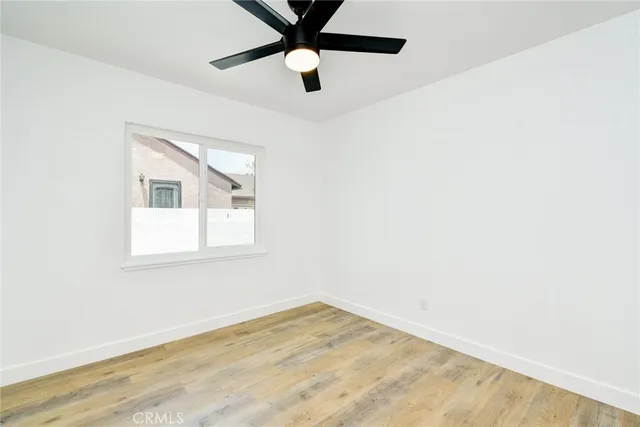 an empty room with a window and a fan