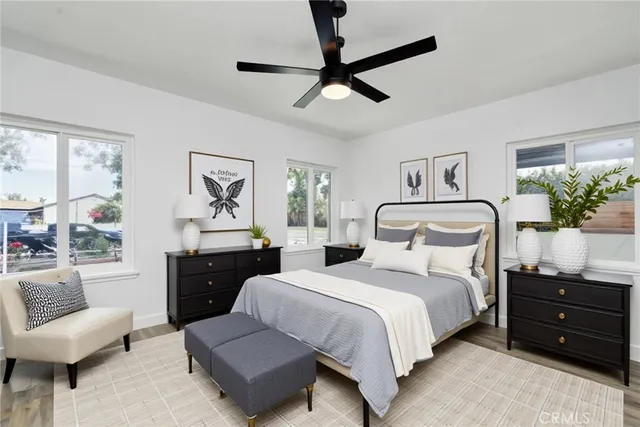 a bedroom with a bed a couch and a potted plant