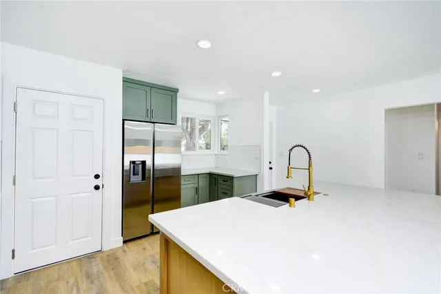 a kitchen with a refrigerator a sink and cabinets