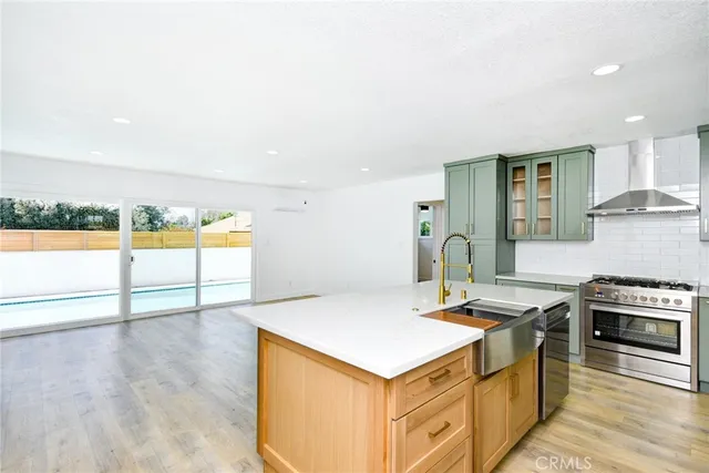 a kitchen with kitchen island a stove a sink and a refrigerator