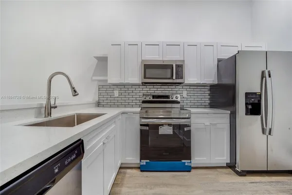 a kitchen with stainless steel appliances a stove sink and refrigerator