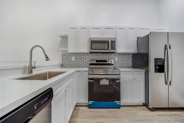 a kitchen with stainless steel appliances a stove sink and refrigerator