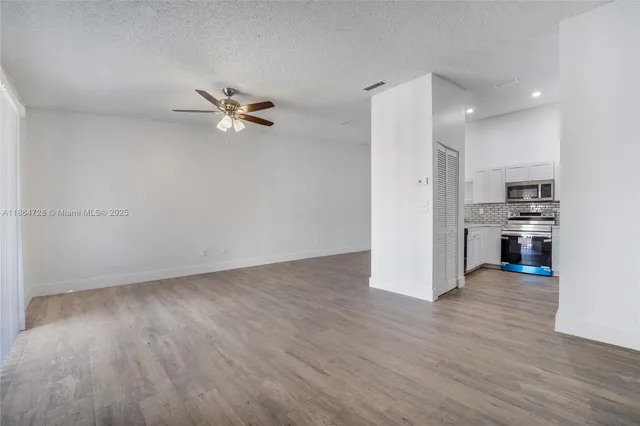 a view of kitchen with hardwood floor and a ceiling fan