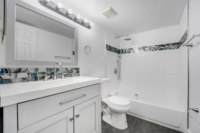 a bathroom with a sink vanity mirror and toilet