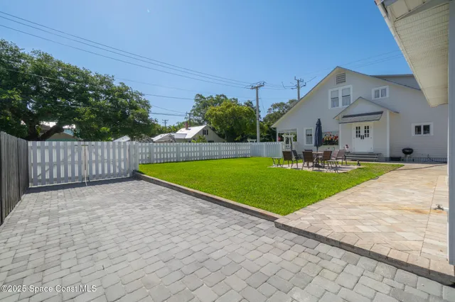 a view of a roof deck with table and chairs a barbeque with wooden floor and fence
