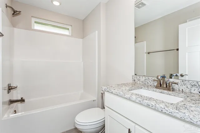 a bathroom with a granite countertop sink a toilet and shower