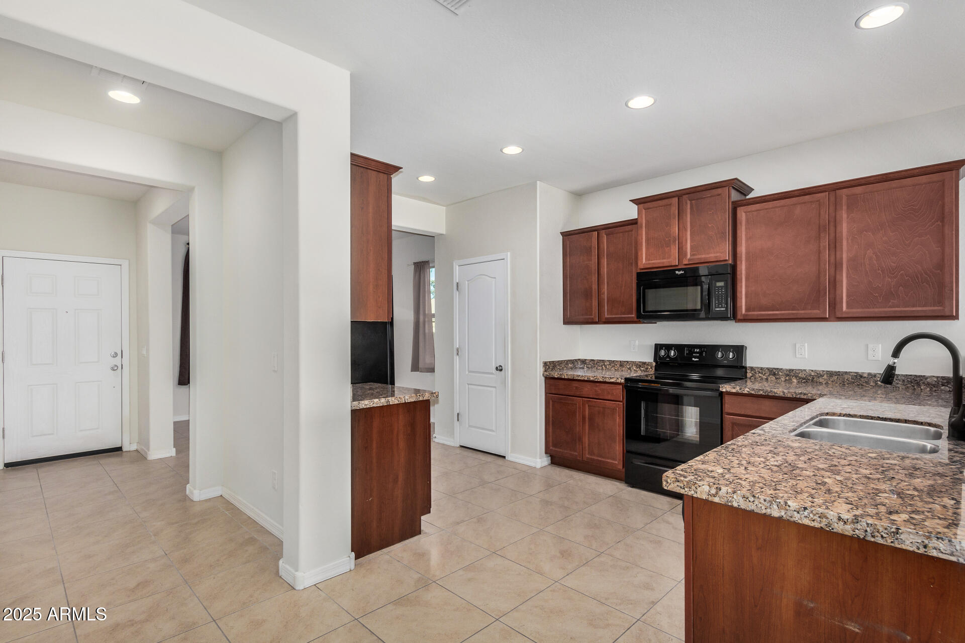 4880 South 246th Lane Buckeye, AZ 85326 - Photo 12 of 32 a kitchen with stainless steel appliances granite countertop a stove top oven a sink and a refrigerator