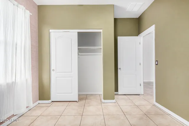 a view of an empty room with cabinet and closet