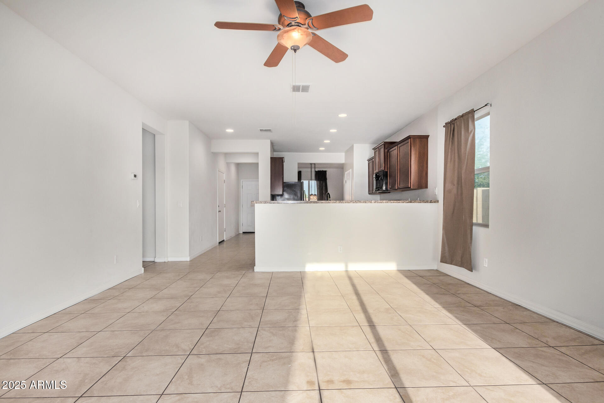 4880 South 246th Lane Buckeye, AZ 85326 - Photo 9 of 32 a view of a livingroom with a ceiling fan and window