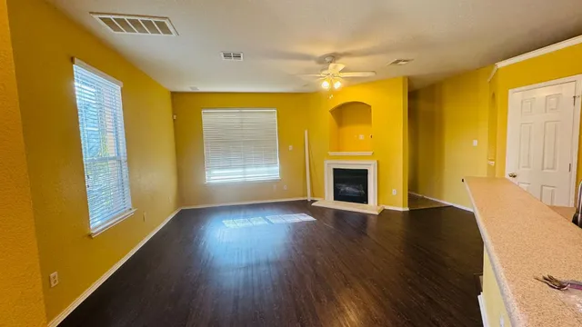 a view of empty room with a fireplace and wooden floor