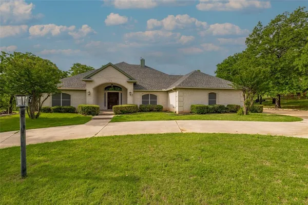 a front view of a house with yard and green space