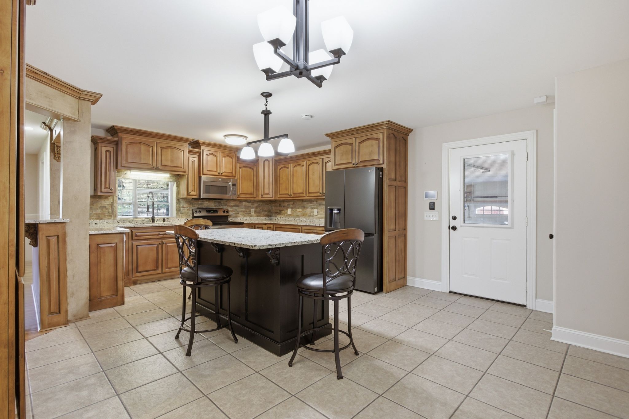 408 Weakley Creek Road Lawrenceburg, TN 38464 - Photo 12 of 41 a kitchen with stainless steel appliances a dining table chairs and granite counter tops