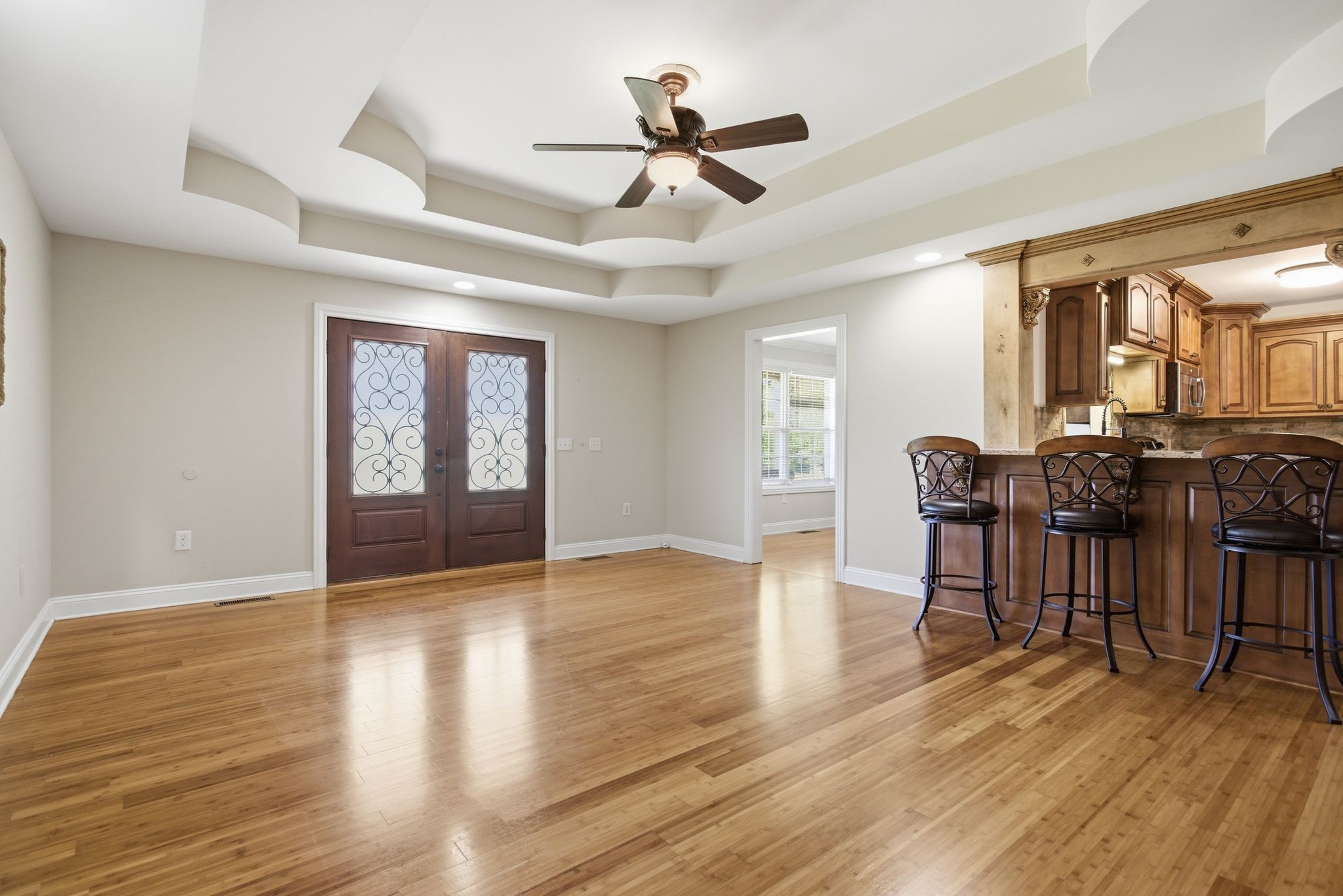 408 Weakley Creek Road Lawrenceburg, TN 38464 - Photo 9 of 41 a view of livingroom and dining room with wooden floor a ceiling fan a fireplace and windows