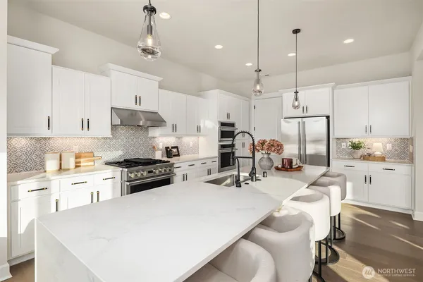 a kitchen with stainless steel appliances sink stove top oven and cabinets
