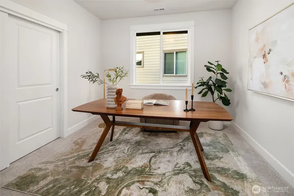 a view of a workspace room with wooden floor and table