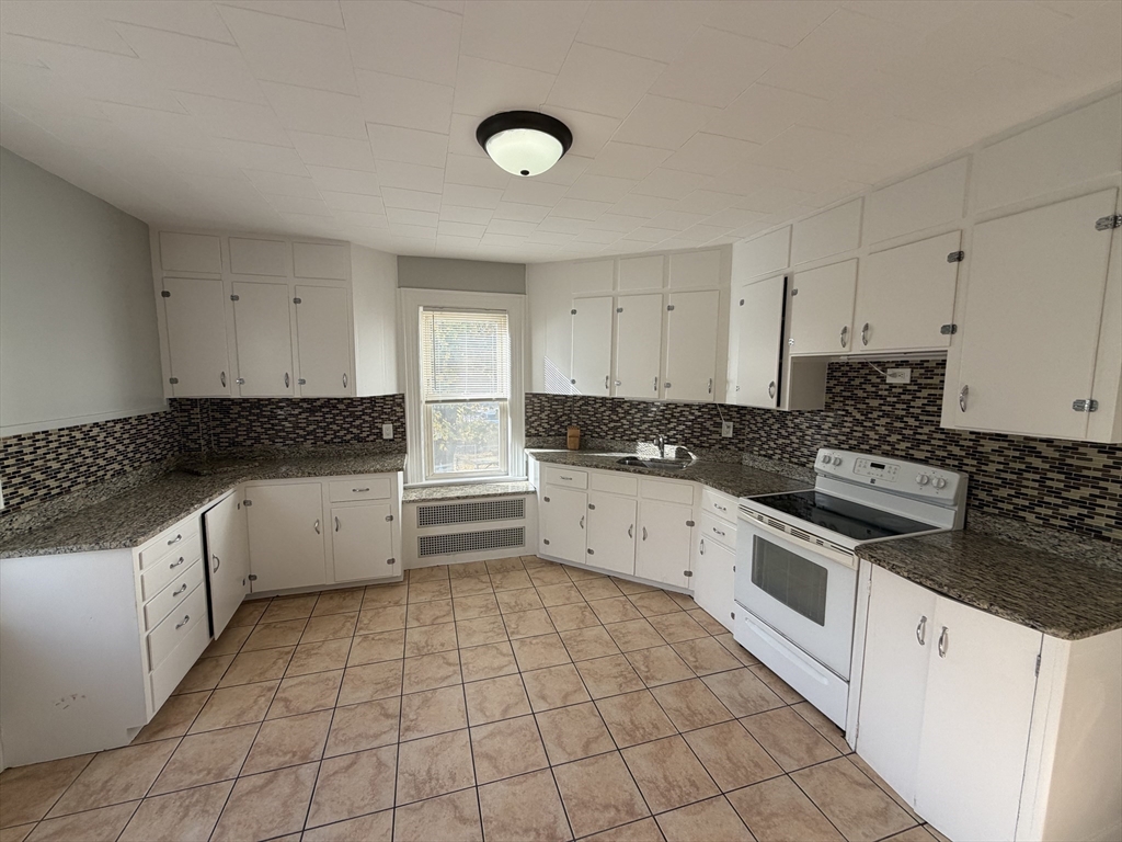 148 George Street, Unit 2 Medford, MA 02155 - Photo 2 of 26 a kitchen with granite countertop white cabinets and white appliances