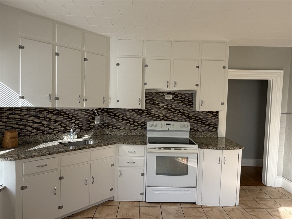 148 George Street, Unit 2 Medford, MA 02155 - Photo 6 of 26 a kitchen with white cabinets and white appliances