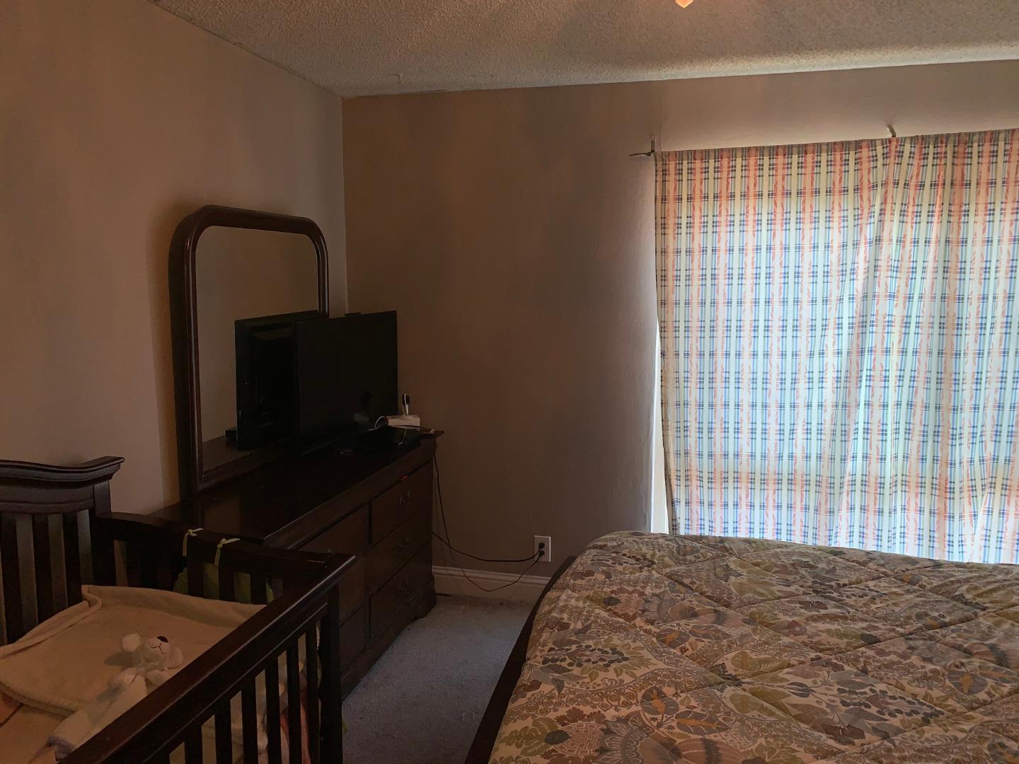 2043 Sierra Road, Unit 1 Concord, CA 94518 - Photo 20 of 34 a bedroom with a bed and a flat tv screen on a dresser