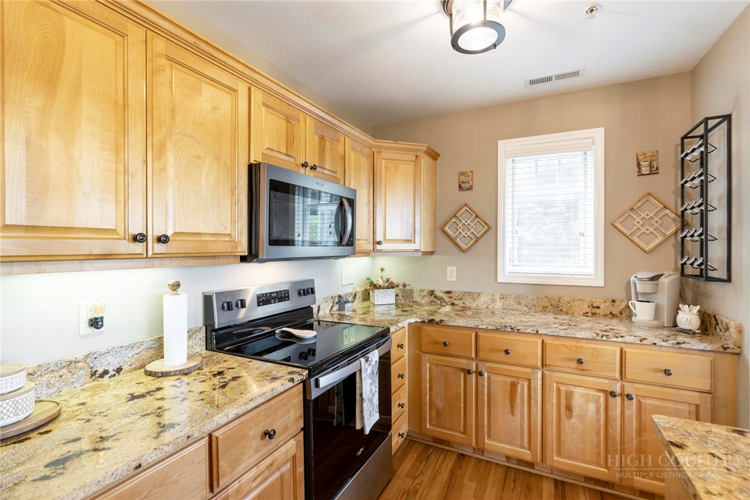 942 Ridge Haven Parkway, Unit R1211 Banner Elk, NC 28604 - Photo 8 of 45 a kitchen with granite countertop a sink stove and microwave