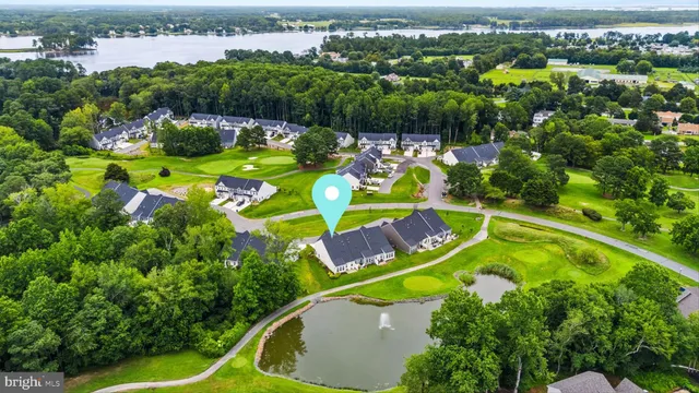 an aerial view of a swimming pool with a yard and outdoor seating