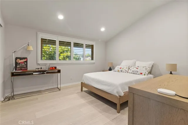 a bedroom with a bed and a dresser next to a window