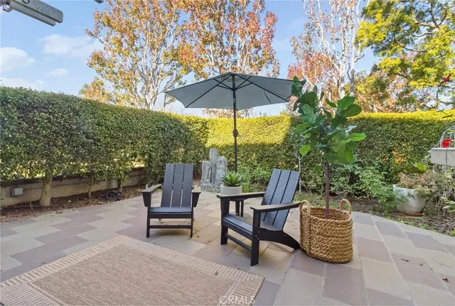 a view of a chairs and table under an umbrella in backyard