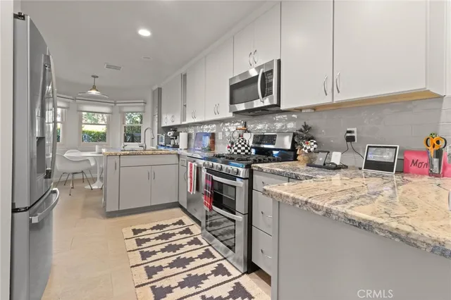 a kitchen with stainless steel appliances kitchen island granite countertop a sink and cabinets