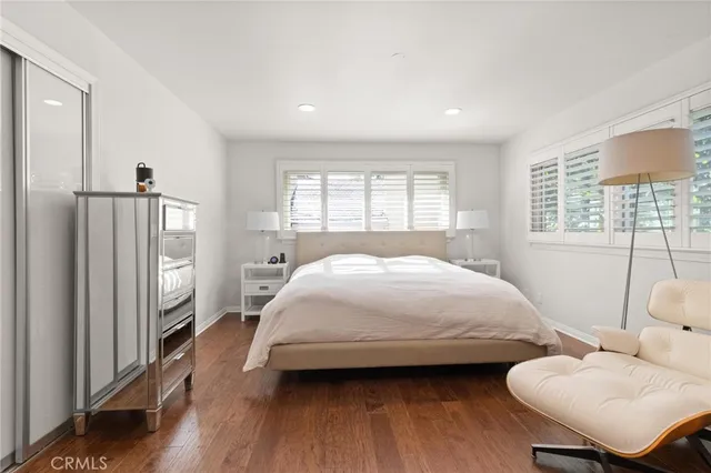 a spacious bedroom with a bed and wooden floor