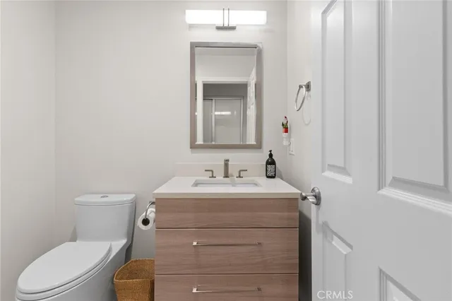 a bathroom with a toilet sink vanity and mirror