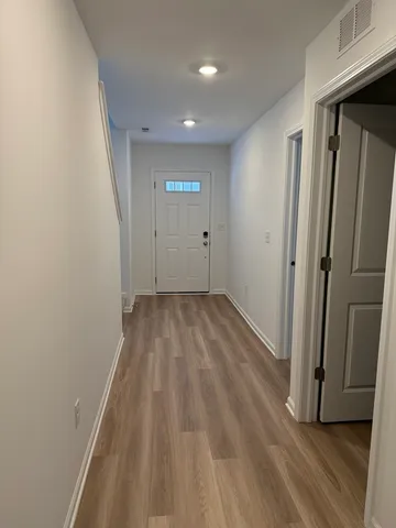 a view of a hallway with wooden floor and a hallway