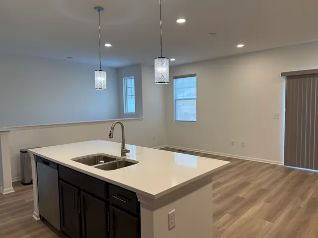 a kitchen with a sink a kitchen island with wooden cabinets