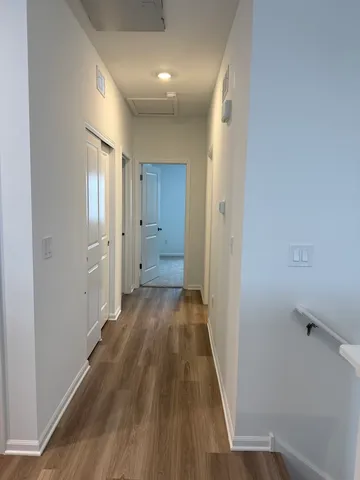 a view of a hallway with wooden floor