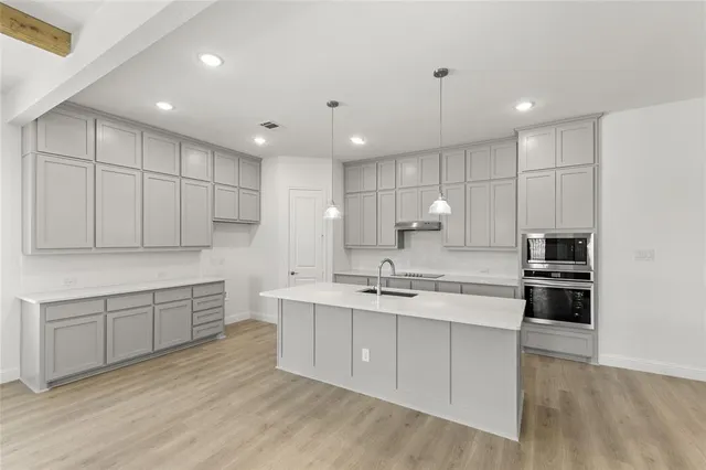 a kitchen with kitchen island white cabinets stainless steel appliances and a sink
