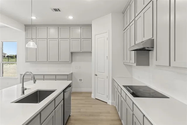 a kitchen with stainless steel appliances granite countertop a sink and a stove top oven