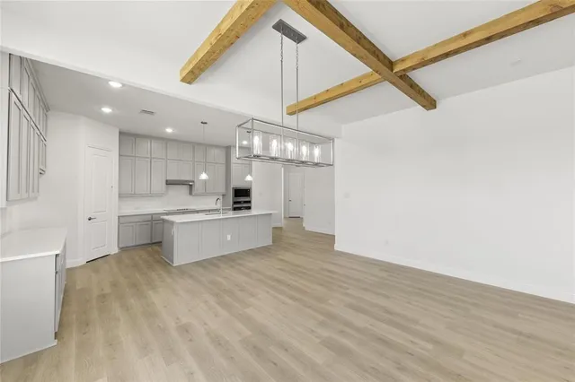 a large kitchen with kitchen island a sink stainless steel appliances and cabinets