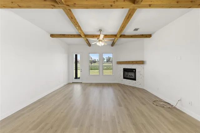a view of an empty room with a fireplace and a window