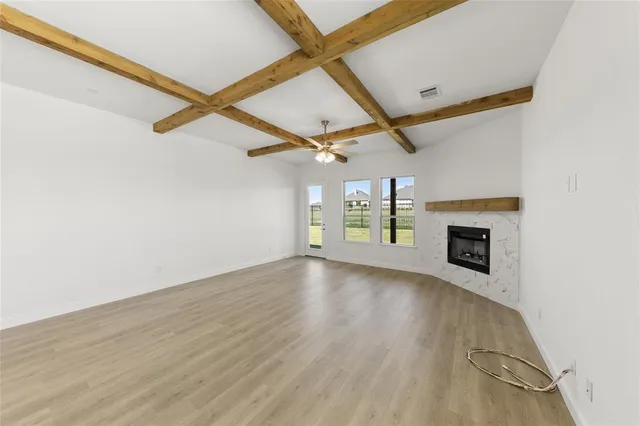 an empty room with windows and fireplace