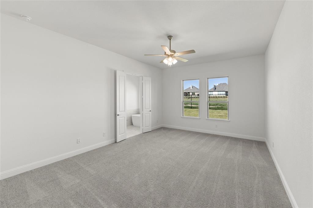 4017 Eagles Bluff Road Midlothian, TX 76065 - Photo 19 of 31 an empty room with windows and ceiling fan