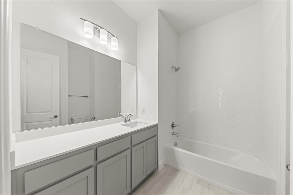 4017 Eagles Bluff Road Midlothian, TX 76065 - Photo 8 of 31 a bathroom with a bathtub and a sink