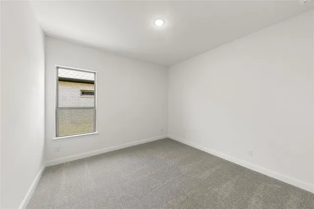 an empty room with a window and mirror