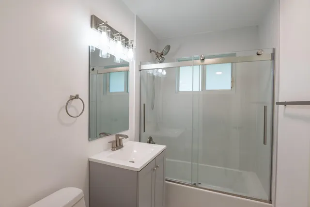 a bathroom with a sink a toilet and shower