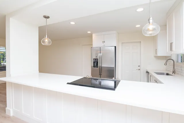 a kitchen with kitchen island a counter top space and stainless steel appliances